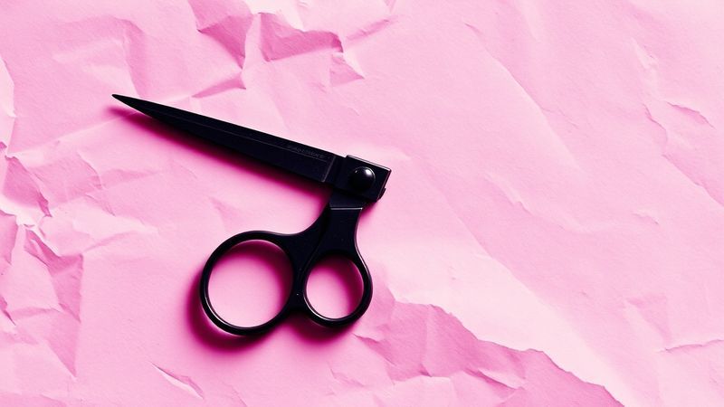 risograph print of scissors lying flat on rumpled paper with deep violet and black inks creating unexpected third color in overlap zones illustration for The Scissors Knew