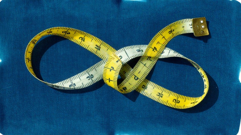 cyanotype of a measuring tape coiled and knotted into an abstract knot illustration for Your Child Will Be Measured
